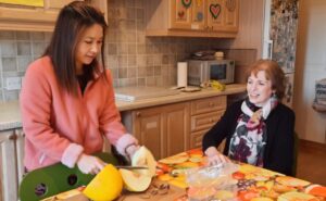 Two people at a kitchen table preparing a meal and enjoying a hapipod homeshare