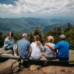 5 friends sitting together looking out upon a mountain view