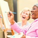 Two people laughing and enjoying an art class together