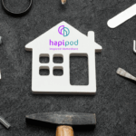 Wooden white house logo with hapipod symbol surrounded by household tools