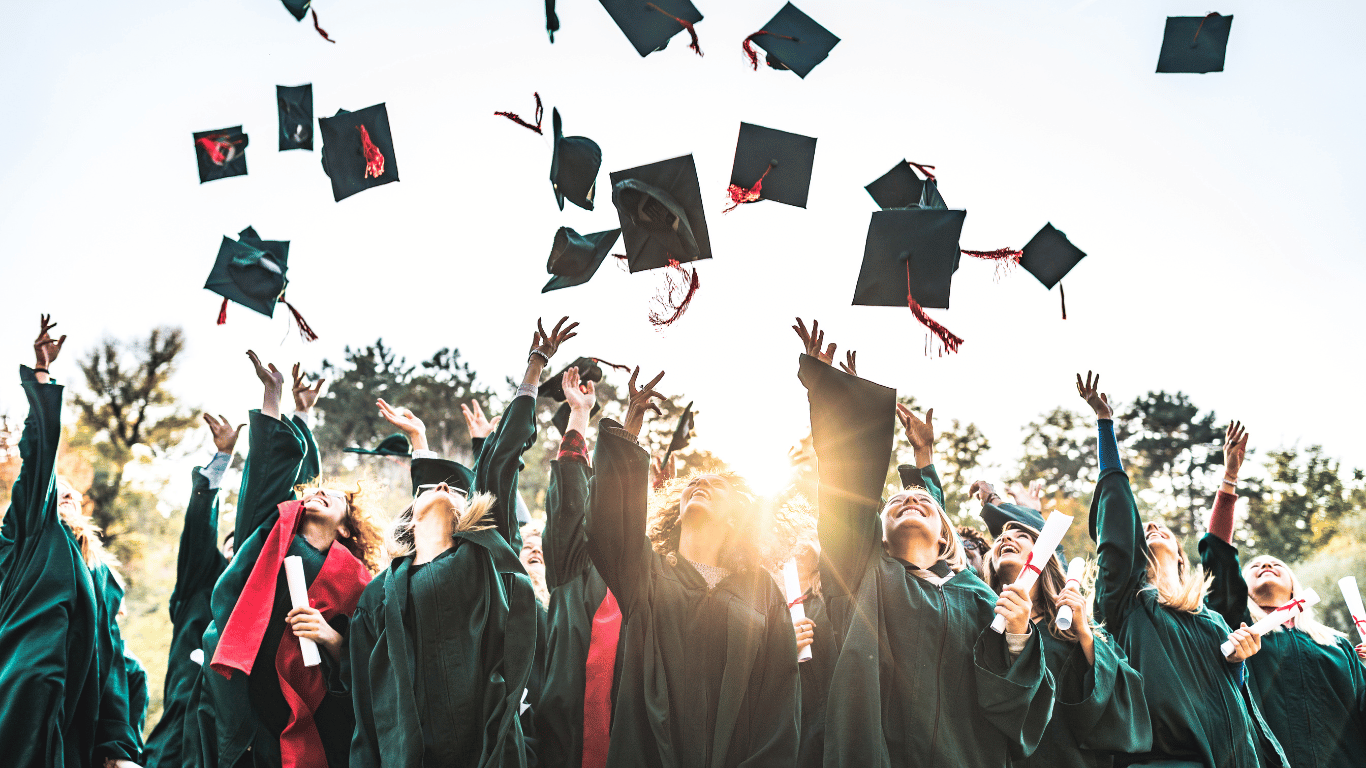 Graduates celebrating graduation by throwing their mortarboards in the air
