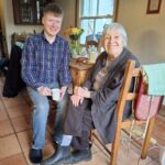 two people sitting at the kitchen table enjoying a cup of tea and discussing the smart homeshare app, hapipod.com