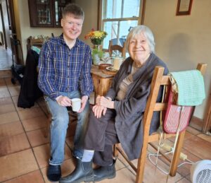 two people sitting at the kitchen table enjoying a cup of tea and discussing the smart homeshare app, hapipod.com
